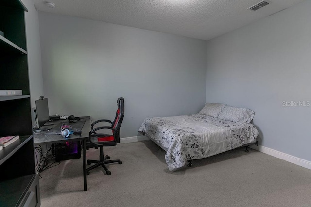 bedroom with light colored carpet and a textured ceiling