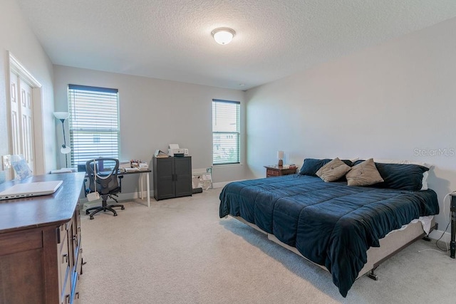 bedroom featuring a textured ceiling and light carpet