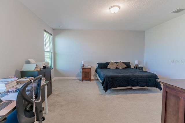 bedroom featuring light carpet and a textured ceiling