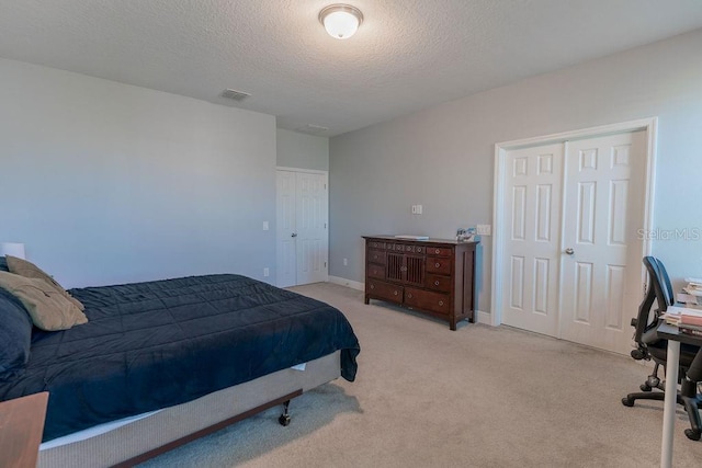 bedroom featuring light carpet and a textured ceiling