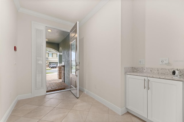 interior space with light tile patterned floors and crown molding