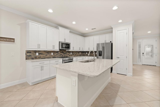 kitchen with white cabinets, stainless steel appliances, a center island with sink, and sink