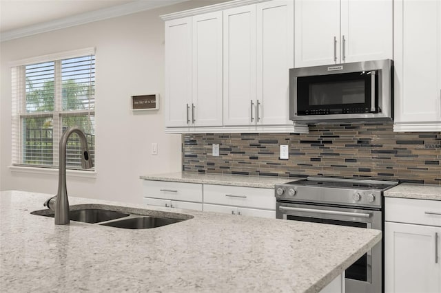 kitchen with light stone countertops, white cabinetry, sink, stainless steel appliances, and crown molding