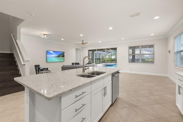 kitchen featuring ceiling fan, sink, light tile patterned floors, a center island with sink, and white cabinets