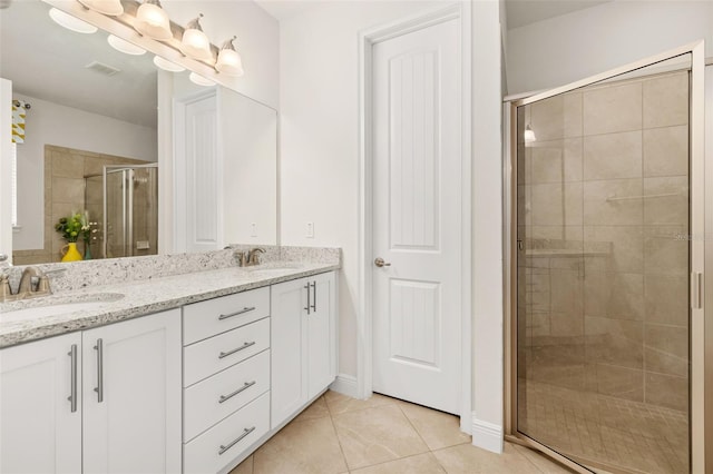 bathroom with tile patterned floors, vanity, and a shower with shower door