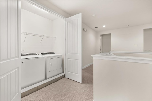 laundry room featuring light carpet and washer and clothes dryer