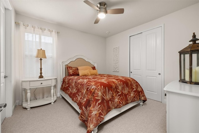 bedroom featuring ceiling fan, a closet, and light carpet