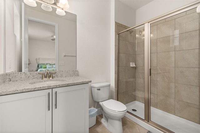 bathroom featuring tile patterned flooring, toilet, an enclosed shower, and vanity