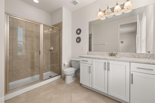 bathroom featuring tile patterned floors, a shower with door, vanity, and toilet