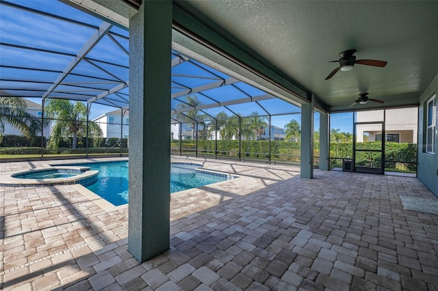 view of pool featuring an in ground hot tub, glass enclosure, ceiling fan, and a patio area