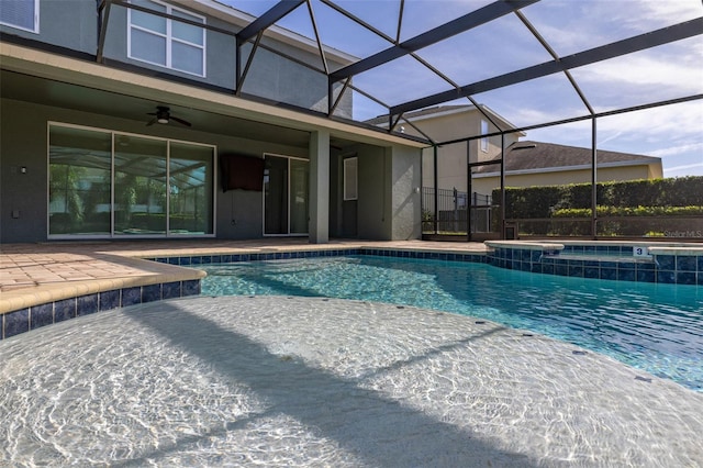 view of swimming pool featuring an in ground hot tub, a patio, glass enclosure, and ceiling fan