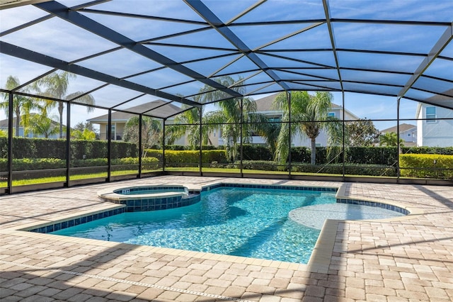 view of pool featuring glass enclosure, an in ground hot tub, and a patio