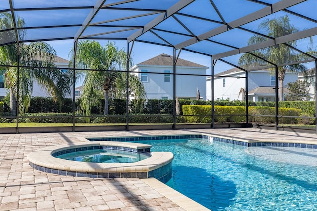 view of swimming pool with glass enclosure and an in ground hot tub