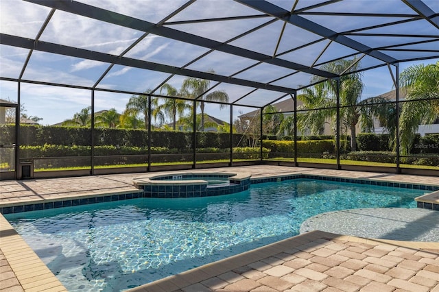 view of pool with glass enclosure, a patio area, and an in ground hot tub