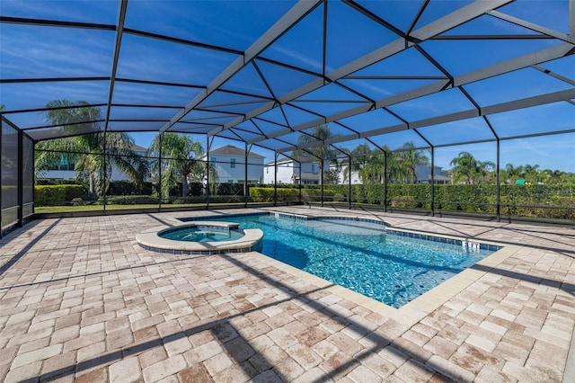 view of pool featuring an in ground hot tub, glass enclosure, and a patio area