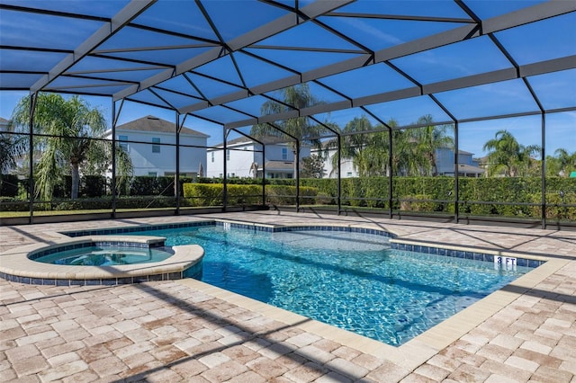 view of pool featuring an in ground hot tub, glass enclosure, and a patio area