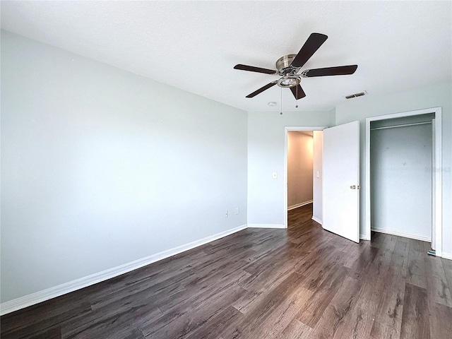 unfurnished bedroom with ceiling fan, dark hardwood / wood-style floors, and a closet