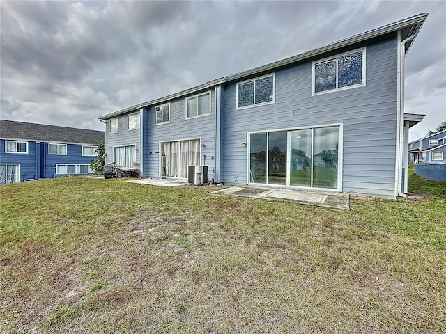 back of property featuring cooling unit and a lawn