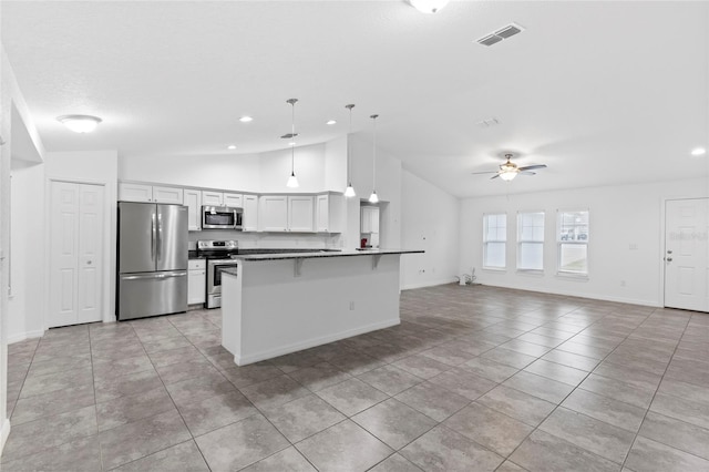 kitchen with ceiling fan, hanging light fixtures, a breakfast bar, white cabinets, and appliances with stainless steel finishes