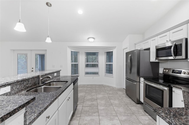 kitchen with stainless steel appliances, sink, pendant lighting, dark stone countertops, and white cabinets