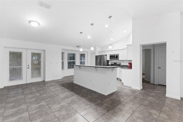 kitchen with pendant lighting, white cabinets, a kitchen island, a kitchen bar, and stainless steel appliances