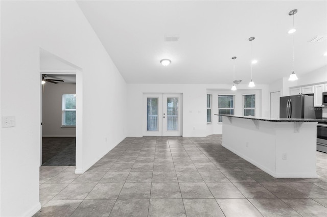 kitchen featuring appliances with stainless steel finishes, a breakfast bar, ceiling fan, decorative light fixtures, and white cabinetry