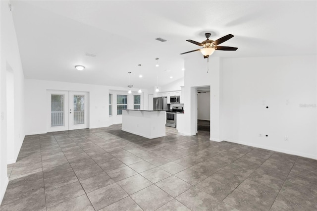 unfurnished living room with tile patterned floors, ceiling fan, french doors, and vaulted ceiling