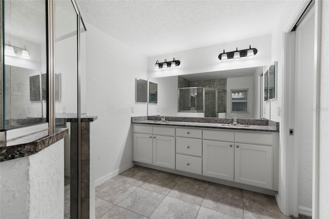 bathroom featuring a textured ceiling, tile patterned flooring, vanity, and an enclosed shower