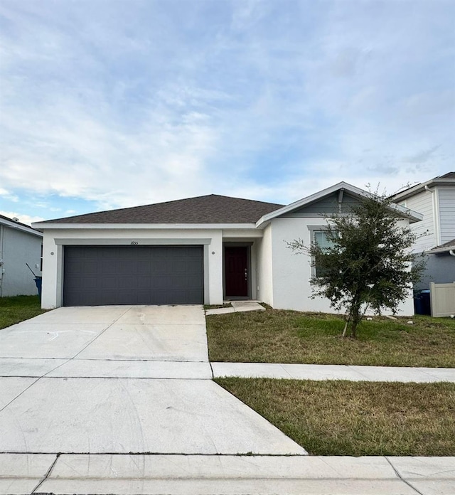 view of front of property featuring a front yard and a garage