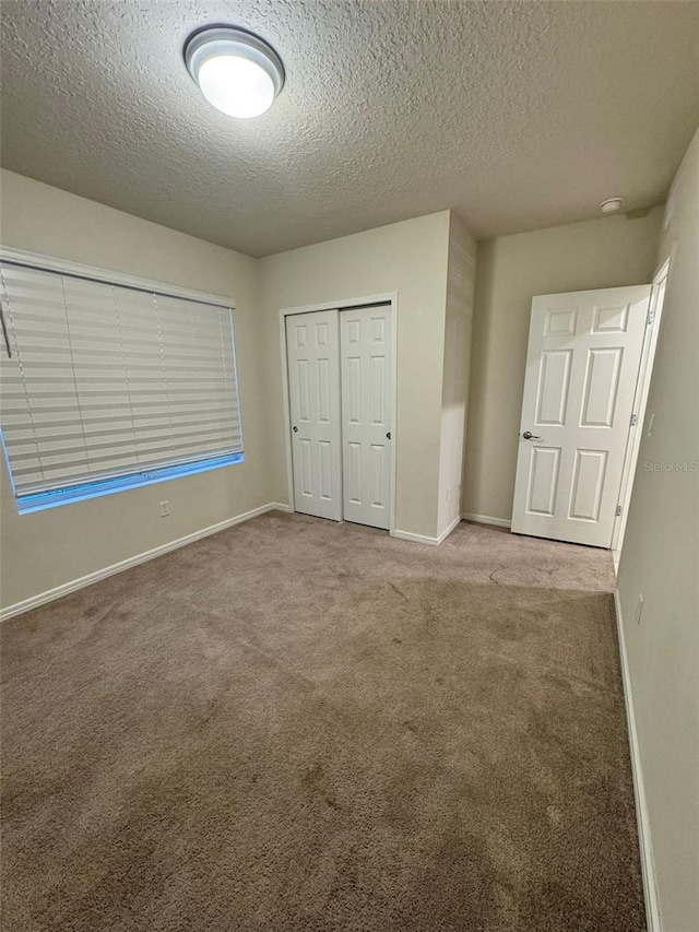 unfurnished bedroom with a textured ceiling, light carpet, and a closet