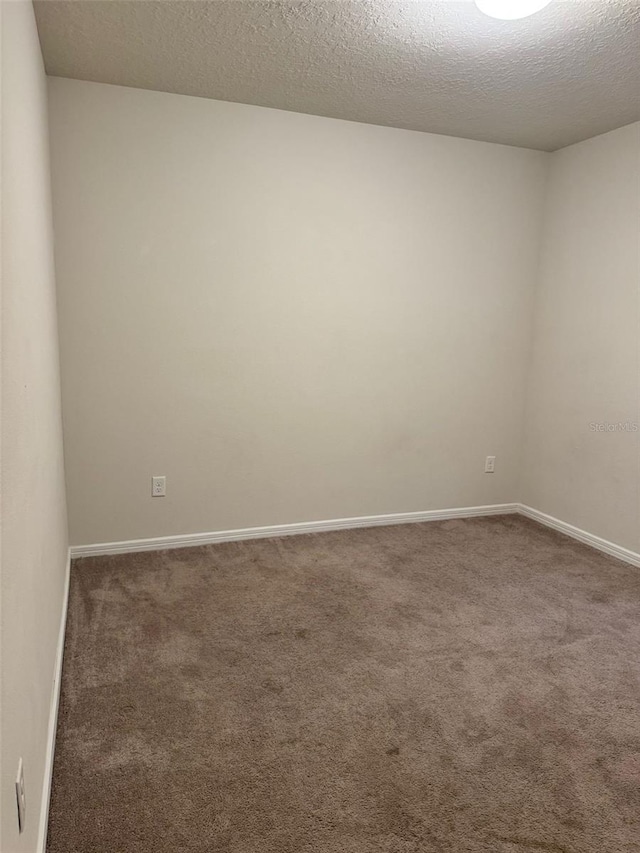 carpeted spare room featuring a textured ceiling