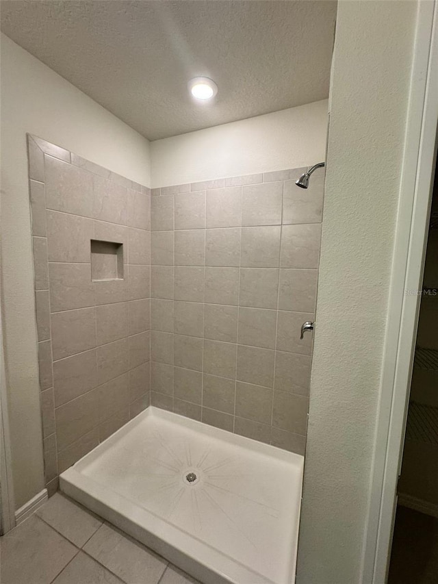 bathroom with tile patterned flooring and walk in shower