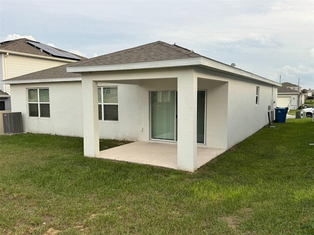 rear view of house featuring central air condition unit, a patio area, and a lawn