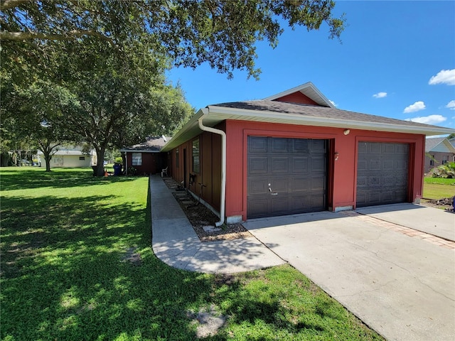 view of side of home featuring a garage and a yard