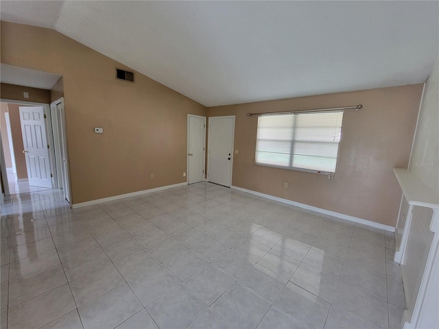 unfurnished room featuring light tile patterned flooring and lofted ceiling