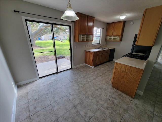 kitchen with a textured ceiling, sink, a wall mounted air conditioner, and decorative light fixtures