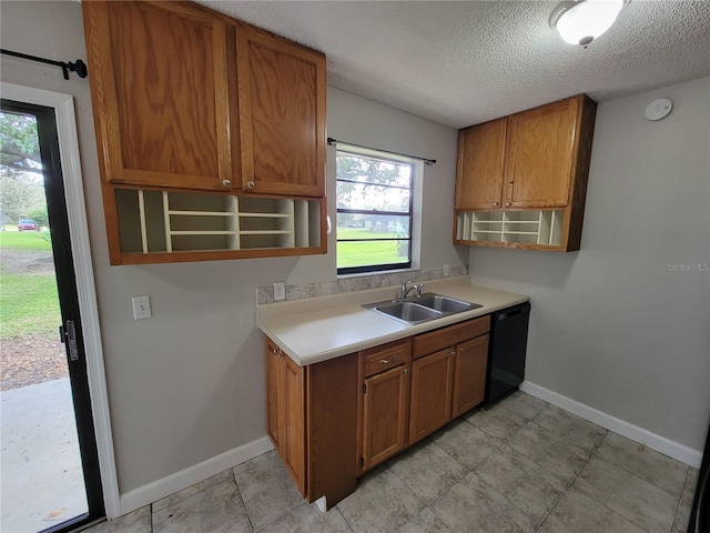 kitchen featuring dishwasher, a textured ceiling, and sink