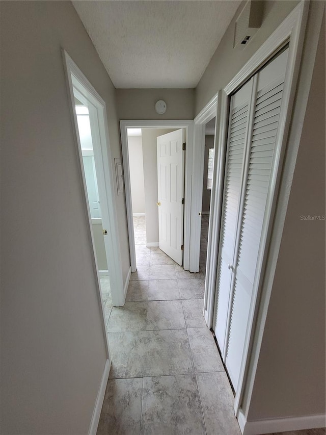 hall featuring a textured ceiling