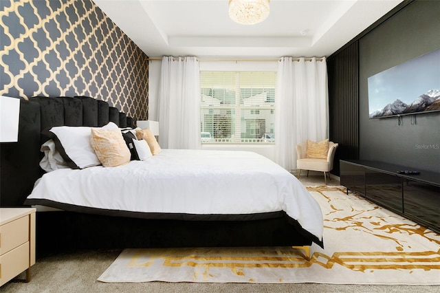 bedroom featuring a raised ceiling and light colored carpet