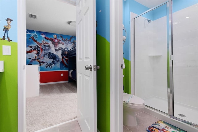 bathroom featuring toilet, tile patterned floors, and walk in shower