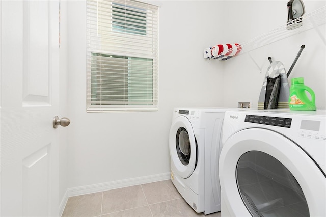 clothes washing area with washing machine and dryer and light tile patterned floors