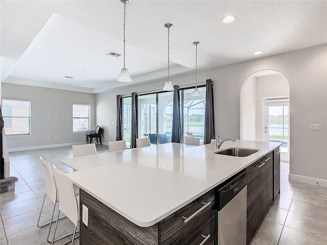 kitchen featuring pendant lighting, a center island with sink, stainless steel dishwasher, and sink