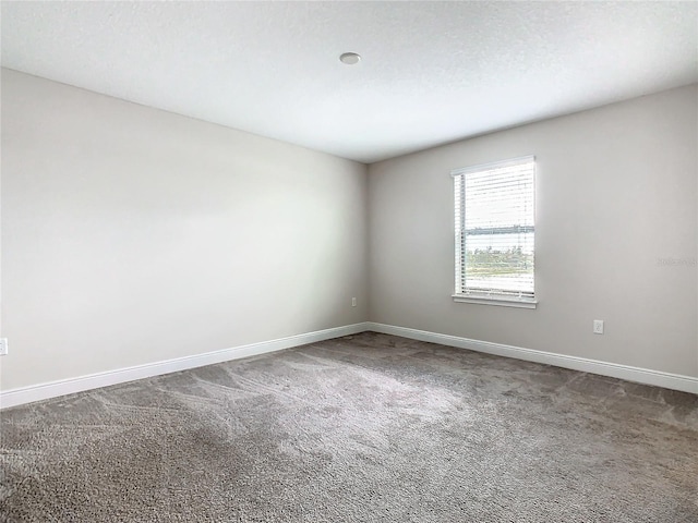 carpeted empty room with a textured ceiling