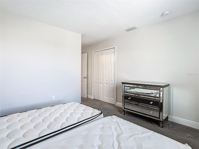 bedroom featuring a closet and dark carpet