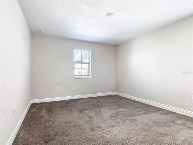 carpeted empty room with a textured ceiling