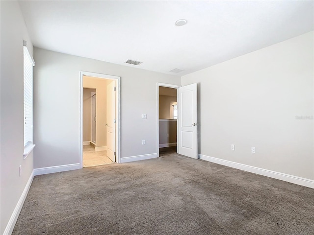 unfurnished bedroom with light carpet and ensuite bath