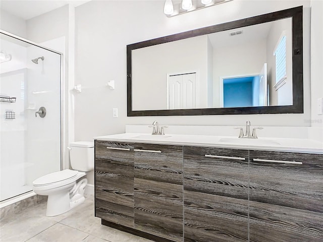 bathroom featuring tile patterned flooring, vanity, a shower with shower door, and toilet