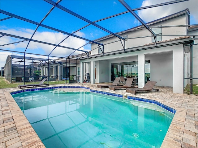 view of pool with a patio and glass enclosure