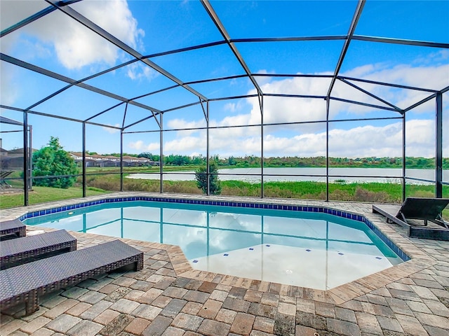 view of pool with glass enclosure, a patio area, and a water view