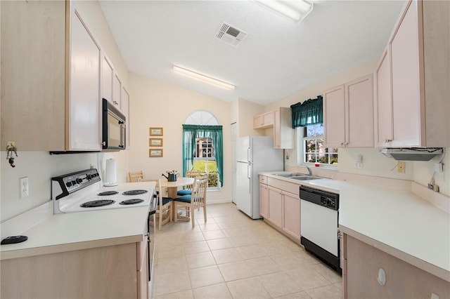 kitchen with sink, a textured ceiling, lofted ceiling, white appliances, and light tile patterned flooring